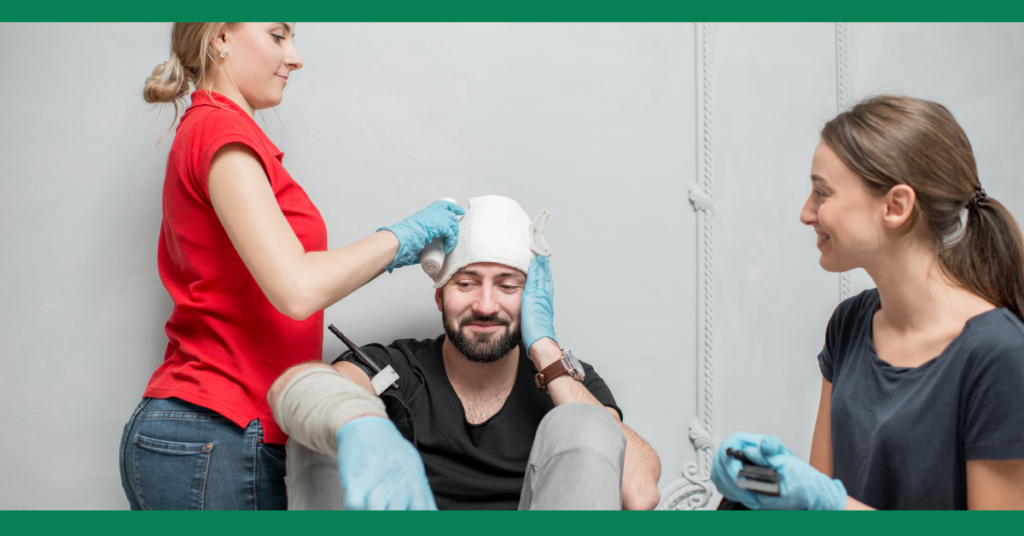 a happy man has a bandage on his head while two confident first aiders help