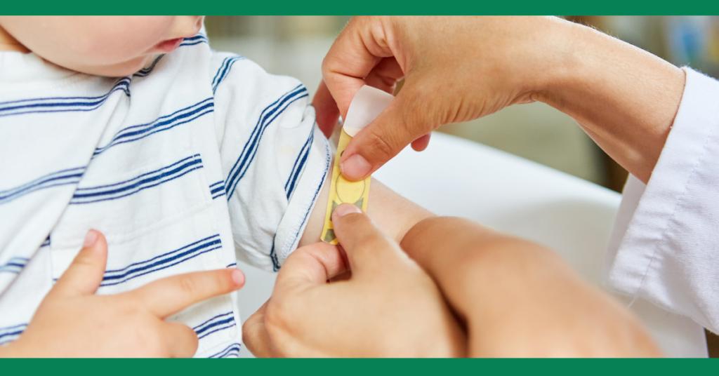  A person applying a bandage to a small child’s arm, showing the careful application of first aid.